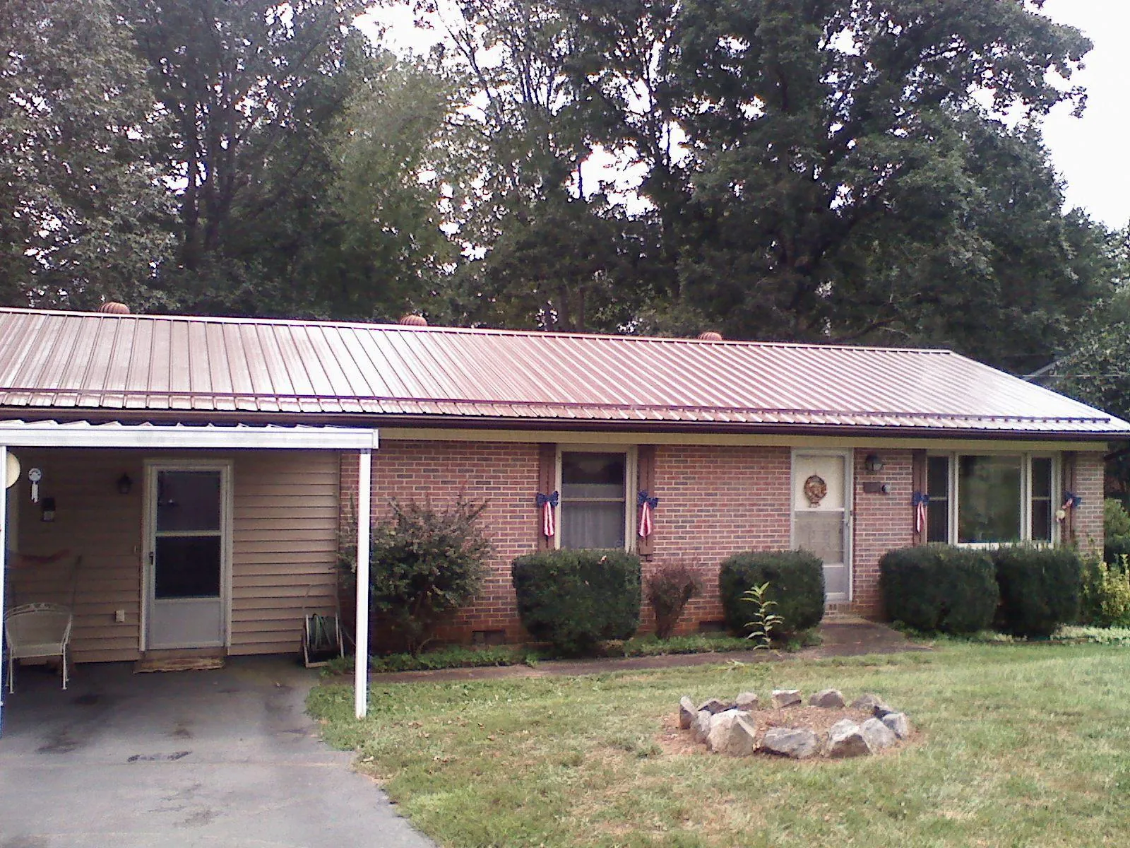 Bronze metal roof and carport on a brick ranch home — Roof Repair work by our crew in Pioneer